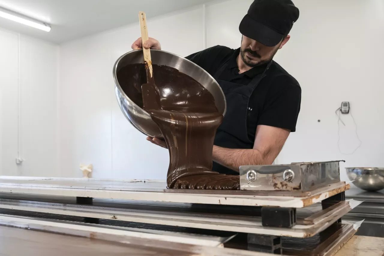 Chocolatier versant du chocolat fondu dans son laboratoire