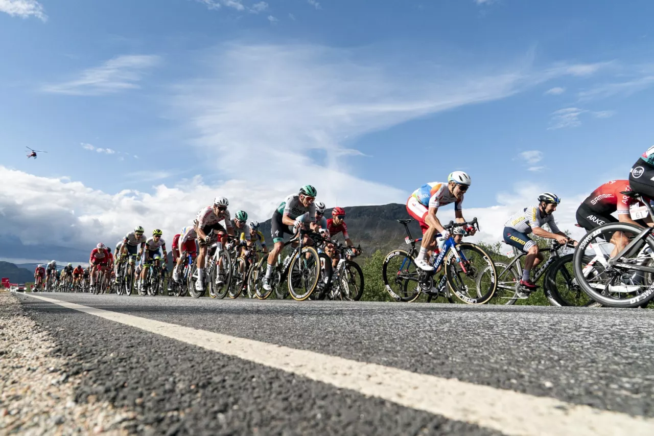 Peloton cycliste au ras du bitume sous un ciel bleu